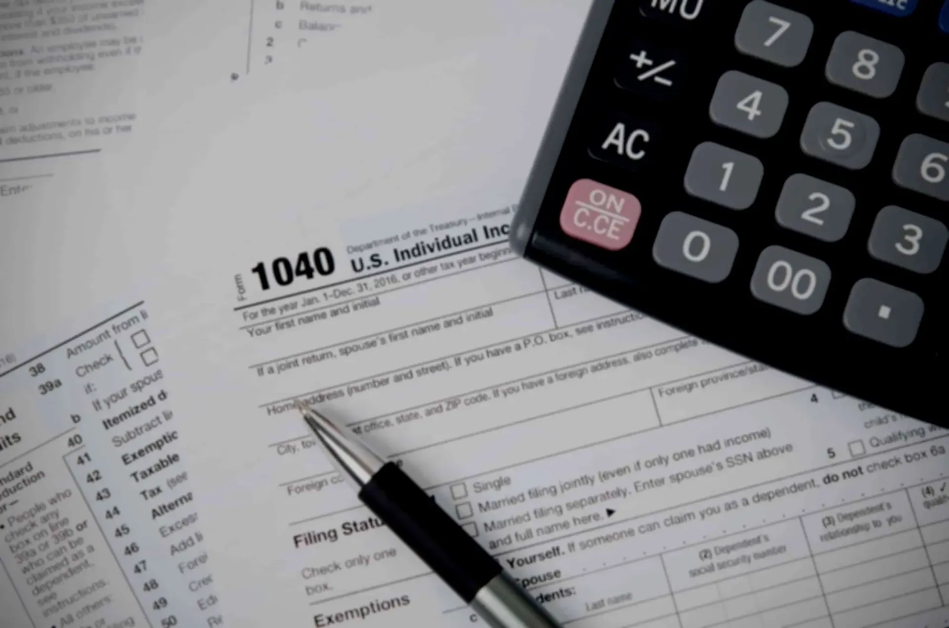 Virtual tax preparation workspace with tax forms, calculator, and pen